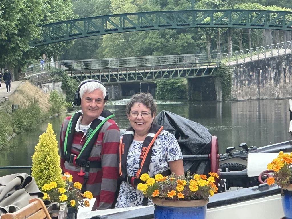 Ian en Lissette glimlachen aan boord van Maria tussen de bloemen, met reddingsvesten aan
