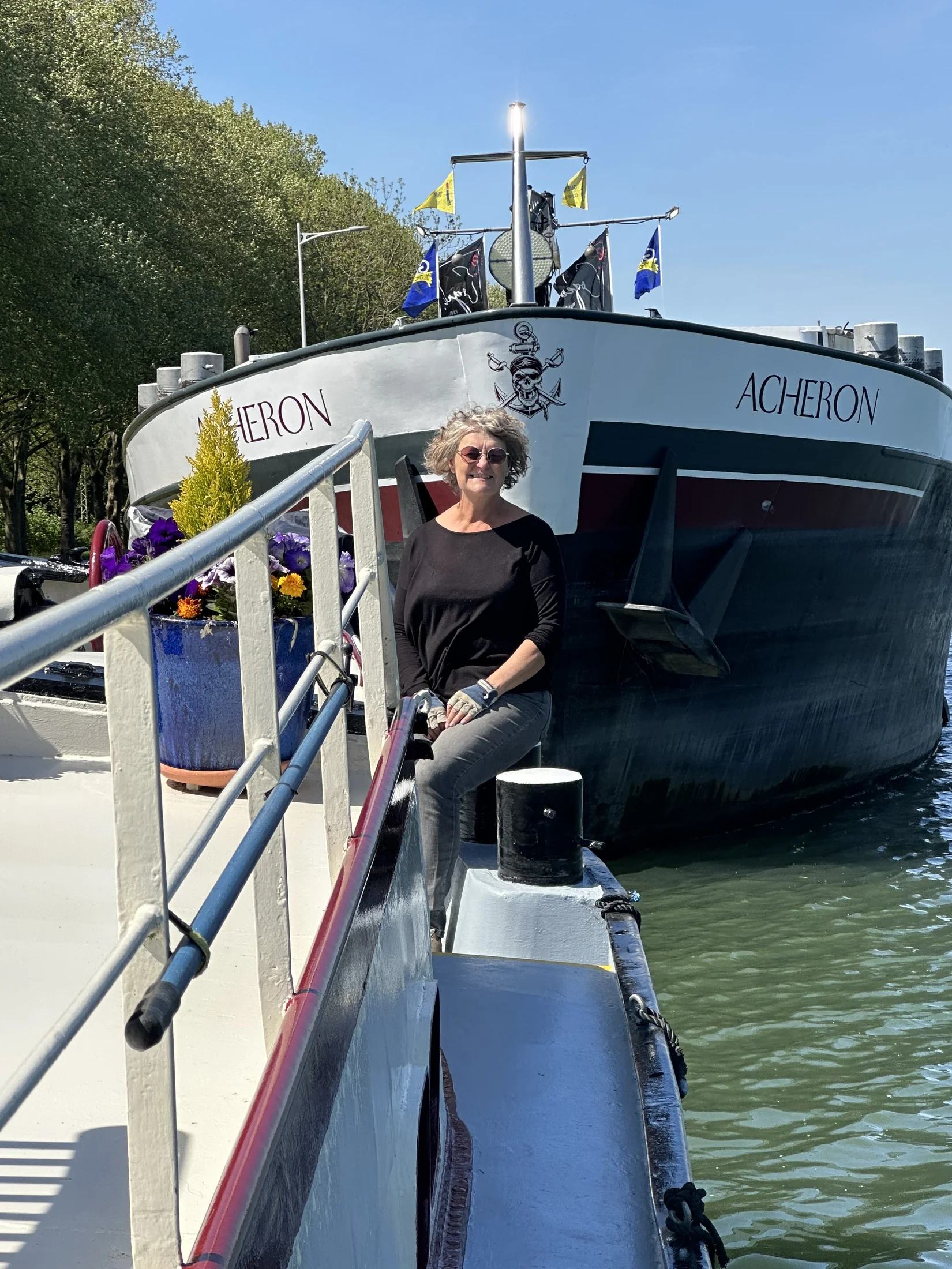 Kaz aan boord van Maria naast de hoge boeg van een veel groter buurschip
