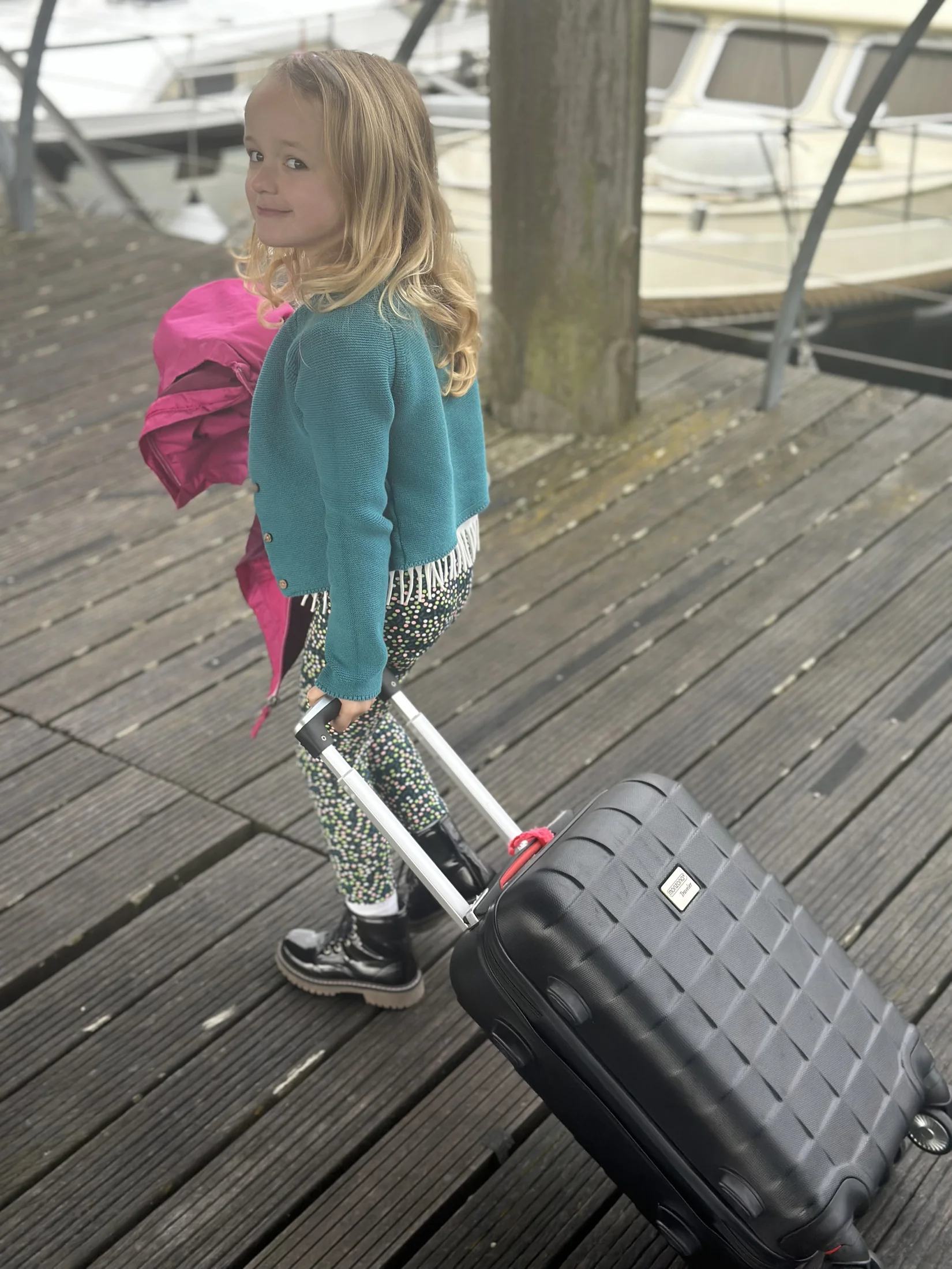 Flo arriveert op het ponton van de jachthaven en trekt haar koffer achter zich aan