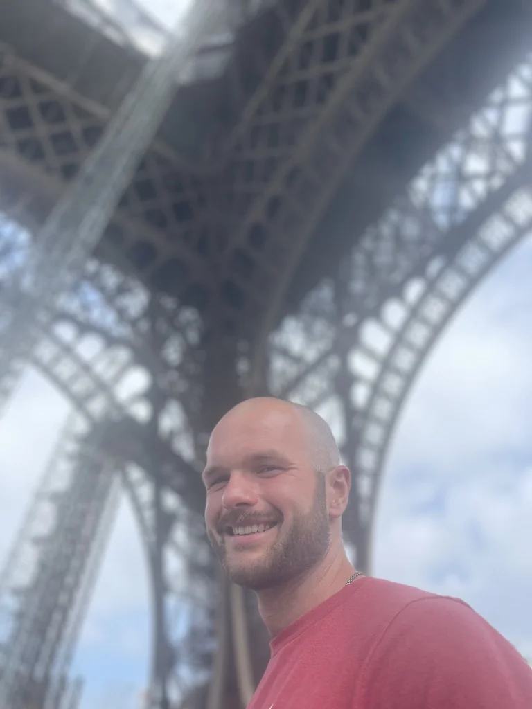 Pete sourit sous la tour Eiffel