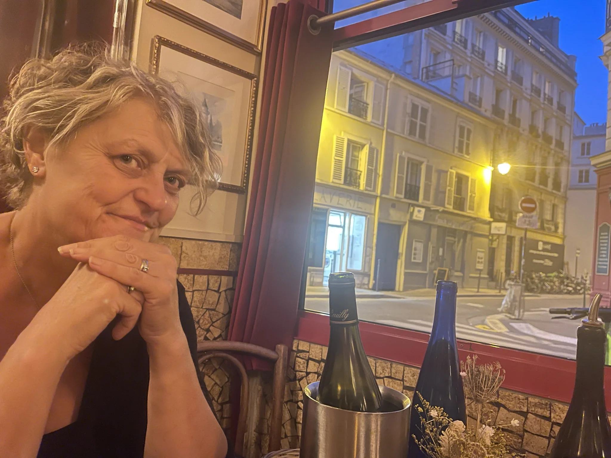 Kaz sourit à table après un délicieux repas dans l’un de nos restaurants parisiens préférés