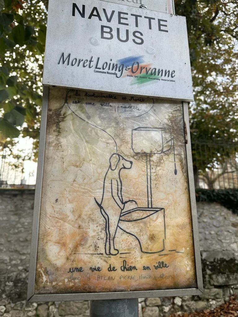 Un panneau humoristique à Moret-sur-Loing demandant aux propriétaires de chiens de garder la rue propre