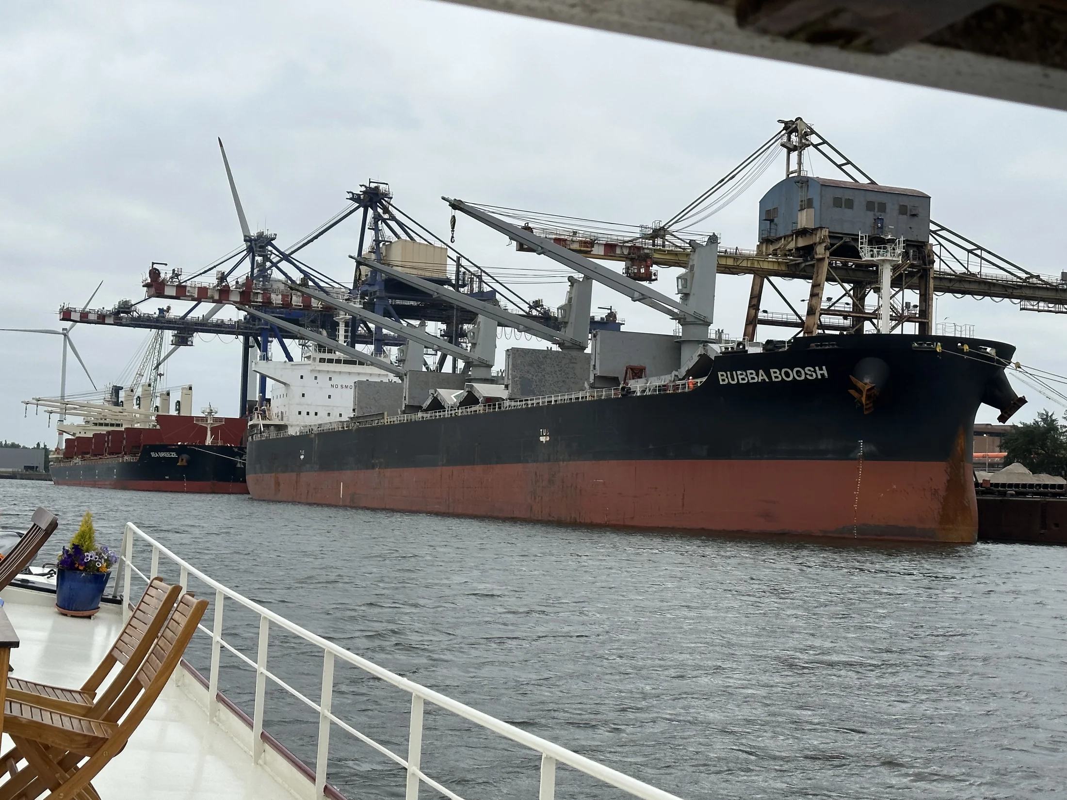 Een groot vrachtschip en havenkranen gezien vanaf Maria’s dek