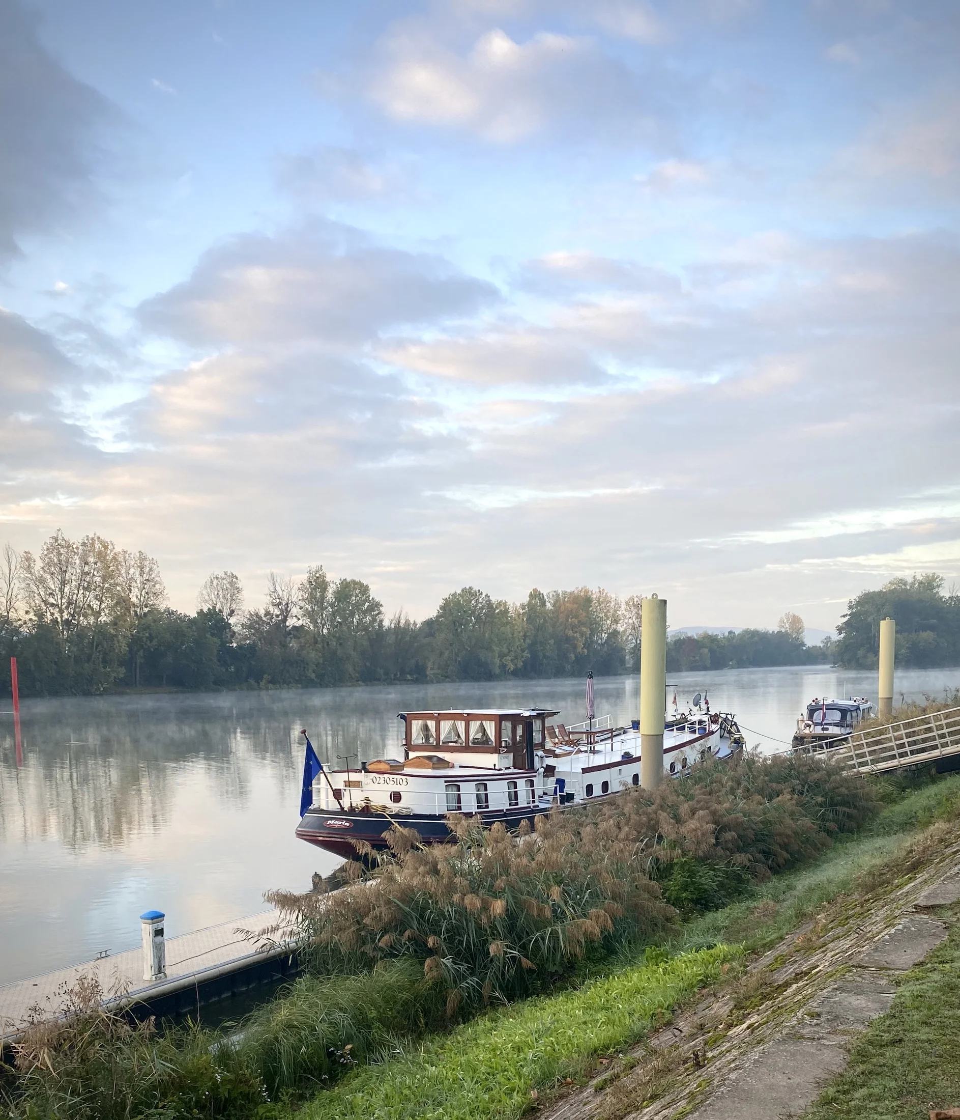 Maria rust op een stille ligplaats aan de rivier onder een herfstlucht