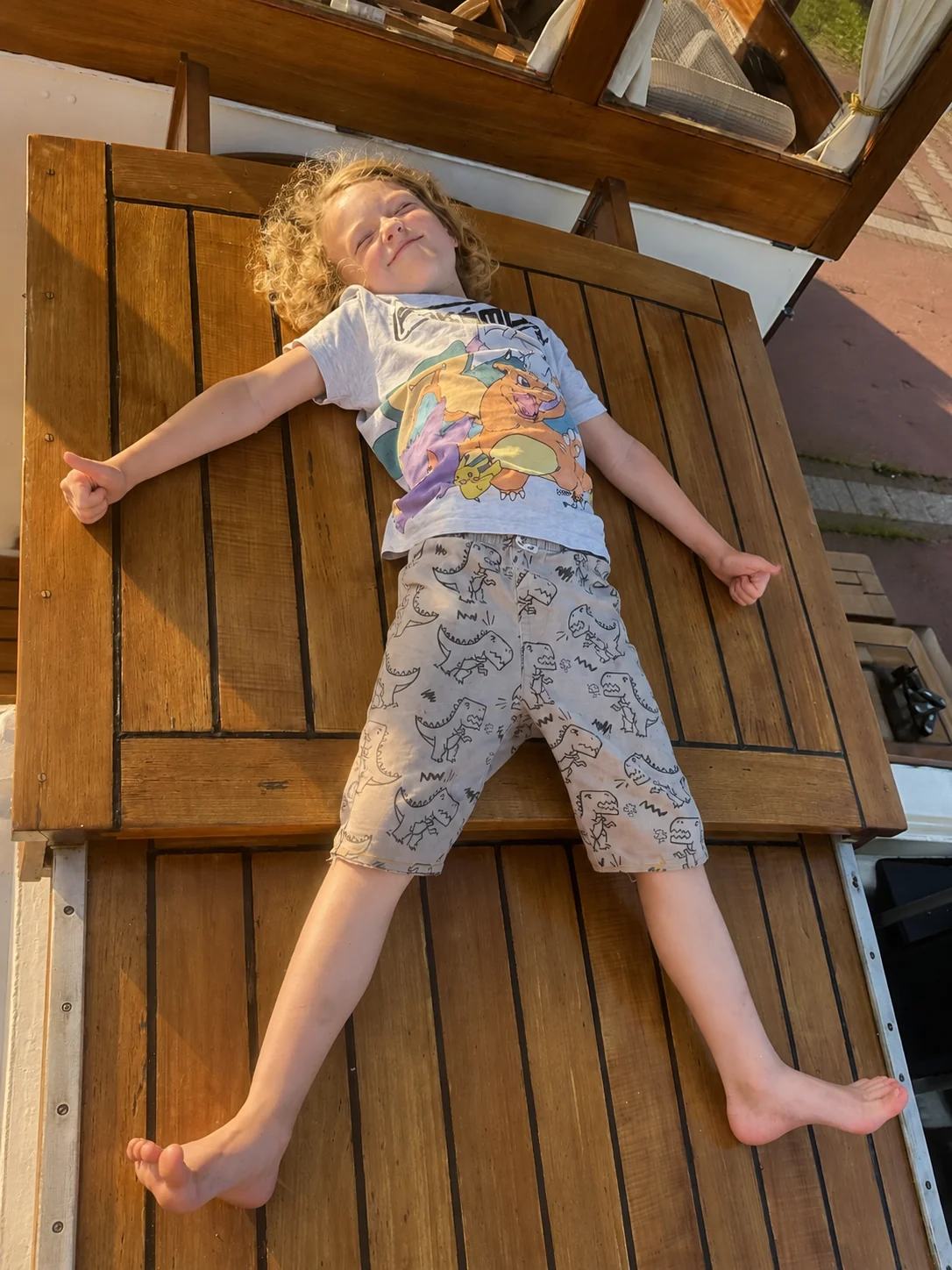 Harry ligt languit en ontspannen op Maria’s houten luik in de zon