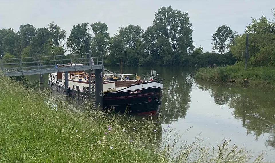 Maria à l’un de ses premiers amarrages, près d’une berge herbeuse et d’une passerelle